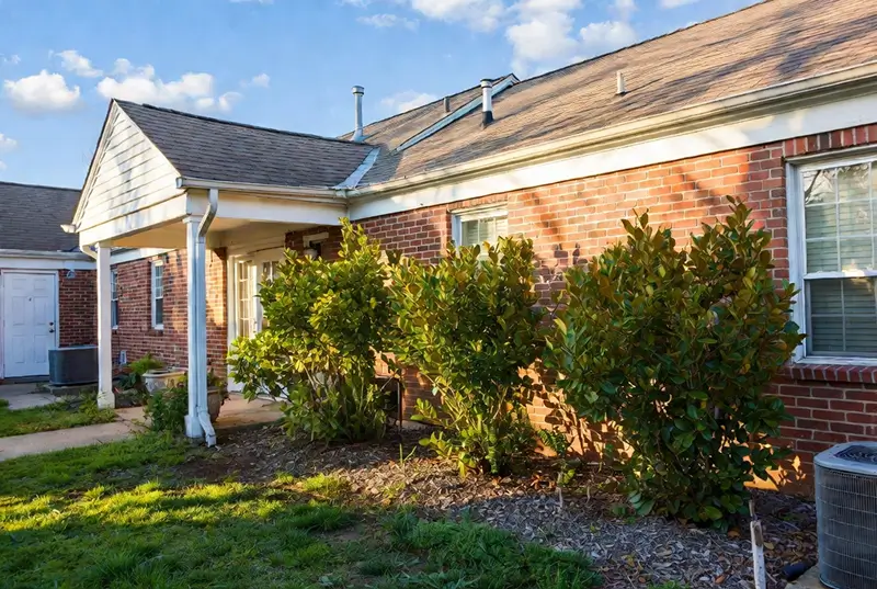 After: Overgrown Shrubs Along Brick House Foundation And Lawn