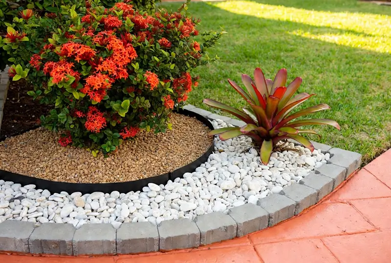 After: Orange Ixora And Bromeliad With Stone Edged Garden Border