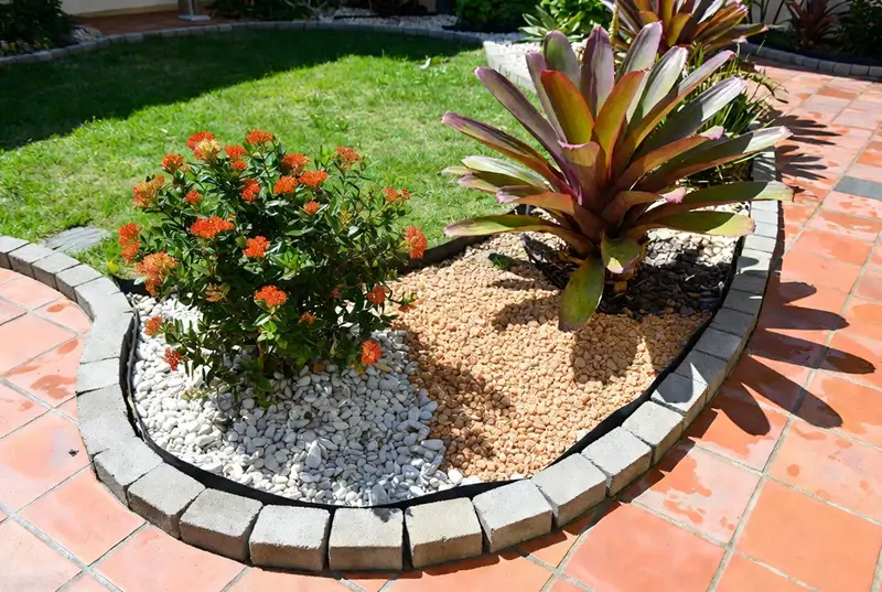 Before: Orange Ixora And Bromeliad With Stone Edged Garden Border